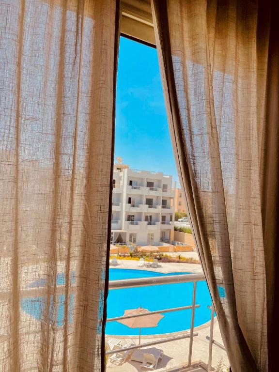 ventana con vistas a la piscina en SHARM ENJOY APARTMENTS en Sharm El Sheikh