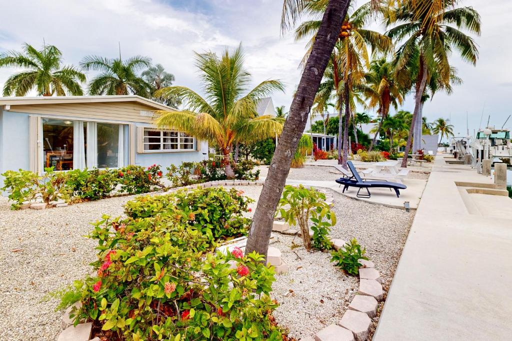 a house with a palm tree and a bench at Fisherman's Canal Getaway in Key Colony Beach
