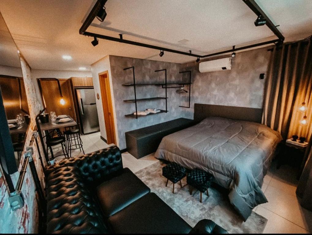 a bedroom with a bed and a couch at Apartamento Luxo Executivo in Bento Gonçalves