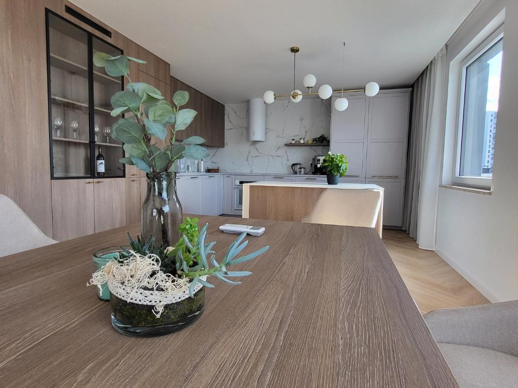 a vase with plants on a wooden table in a kitchen at Timo Baltic View in Gdańsk