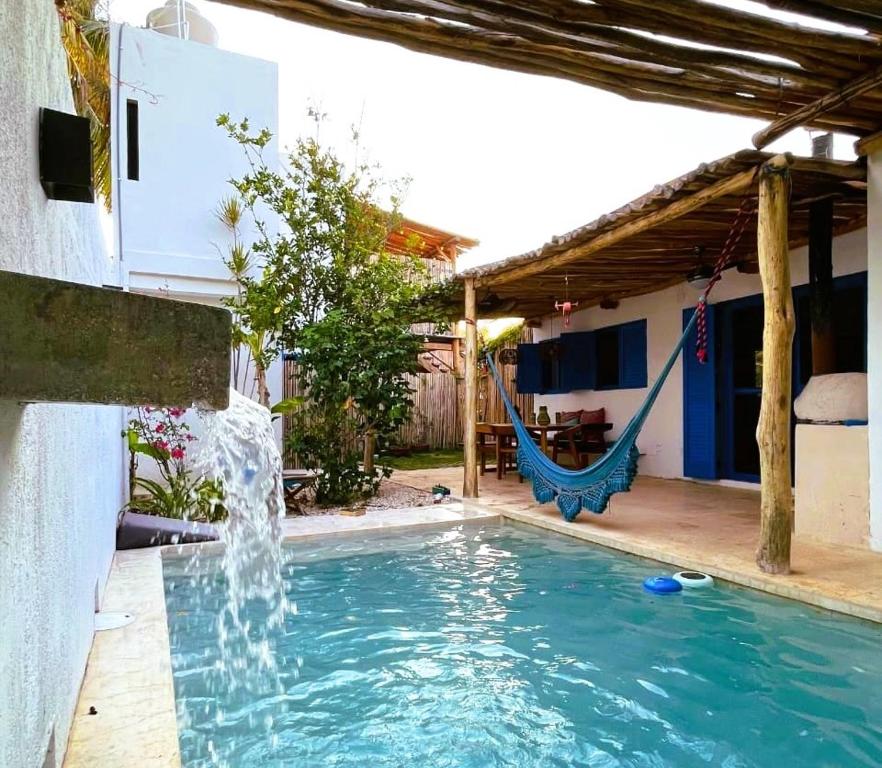 une piscine avec une balançoire et une fontaine dans l'établissement Casa Omero., à El Cuyo