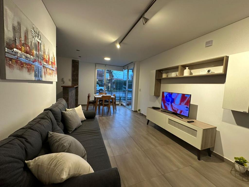 een woonkamer met een bank en een flatscreen-tv bij Simonetta in Puerto Madryn