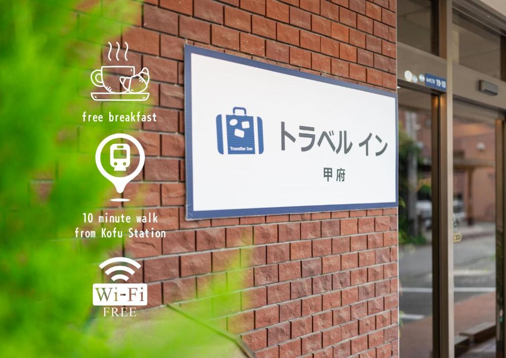 a sign on the side of a brick building at Travel Inn Kofu in Kofu