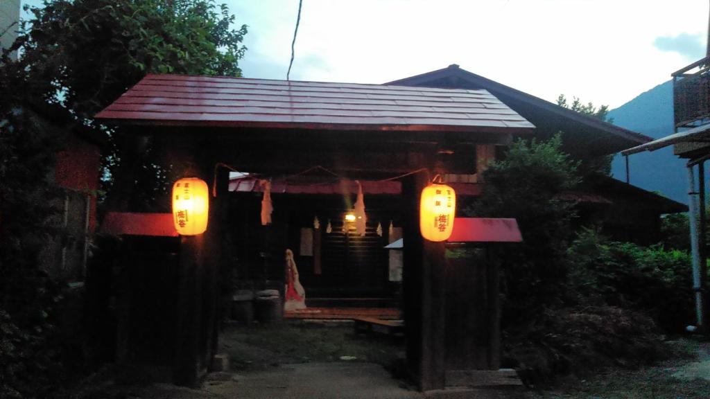 een klein huis met een veranda met verlichting bij 御師の家　梅谷（UMEYA） in Fujikawaguchiko