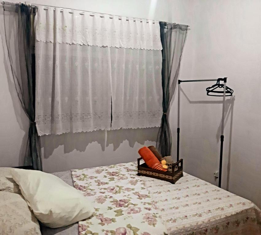 um quarto com uma cama e uma janela com uma cortina em Loft aconchegante - Centro Niterói em Niterói