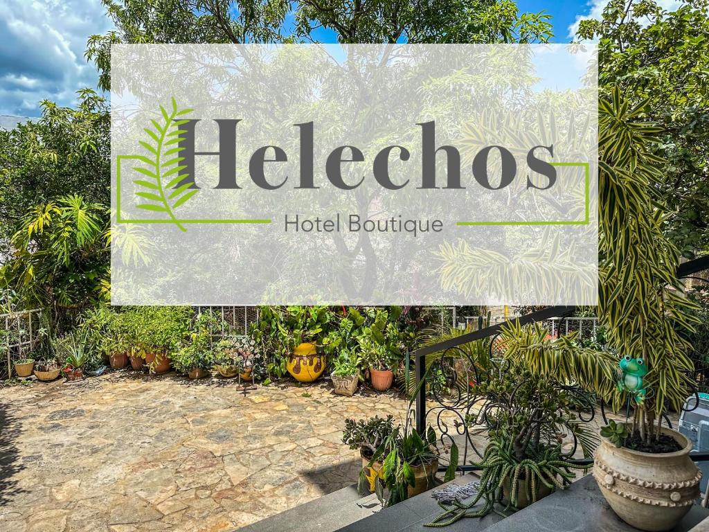 a sign for a hotel boutique with potted plants at Helechos Hotel in Comayagua
