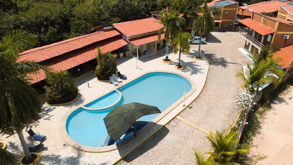 an overhead view of a swimming pool with an umbrella at Chalé Aconchego in Barreirinhas