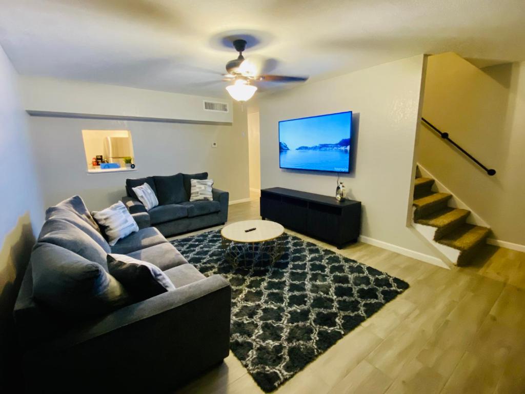 uma sala de estar com um sofá e uma televisão em Modern Hideaway em El Paso