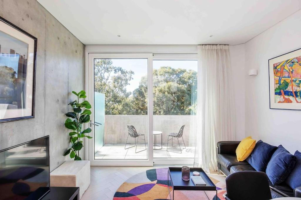 Sustainable Luxury in Australia's 1st Passive Apartment في سيدني: غرفة معيشة مع أريكة ونافذة كبيرة