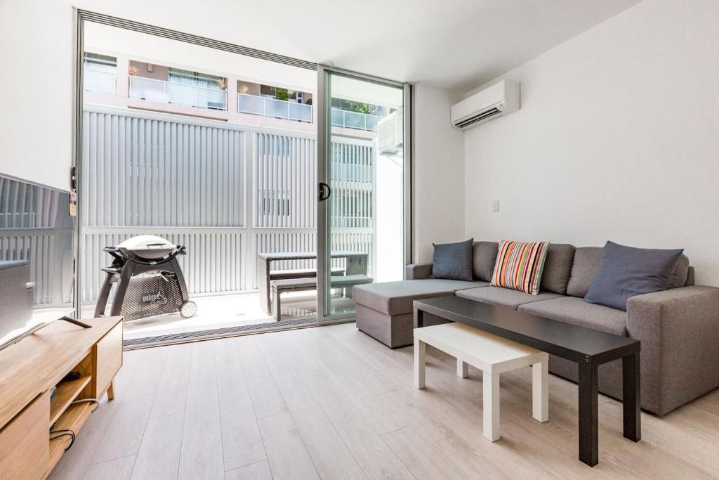 a living room with a couch and a table at Urban Oasis Custom Made for Cosmopolitan Living in Sydney