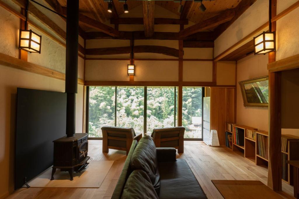 sala de estar con sofá y chimenea en Ryokuinsansou-bettei - Vacation STAY 48641v, en Yasugi