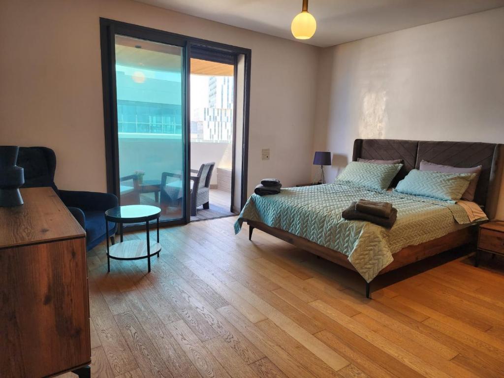 1 dormitorio con 1 cama y puerta corredera de cristal en Appartement de luxe Marina Casablanca, en Casablanca