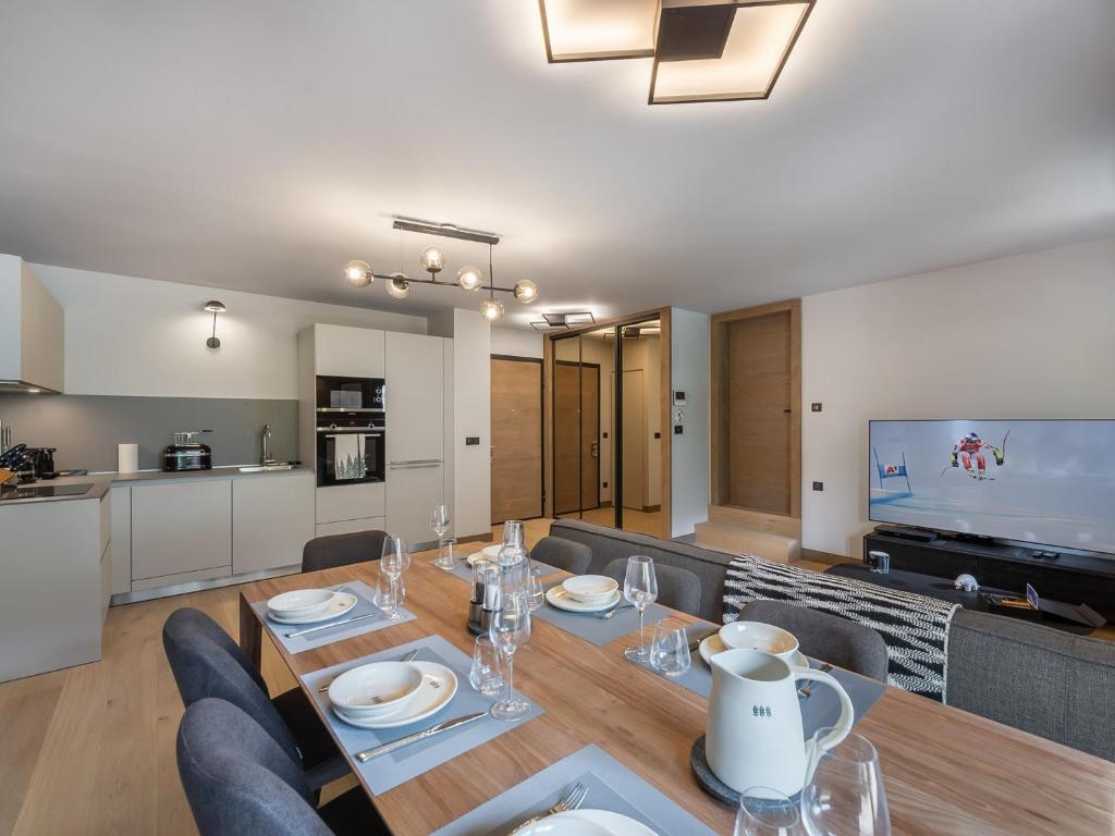 une salle à manger et un salon avec une table et des chaises dans l'établissement Appartement avec piscine, salle de sport et parking couvert - FR-1-569-105, à Megève