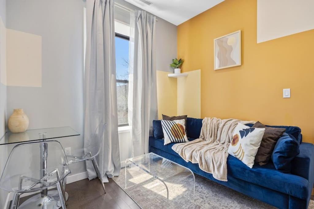 uma sala de estar com um sofá azul e uma janela em SWJ 4th and 5th - Save on 2Day+ Stays_Duplex em Nova York