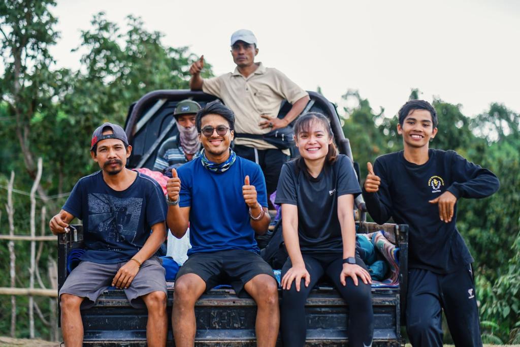 a group of people sitting on the back of a truck at Rinjani in Bayan