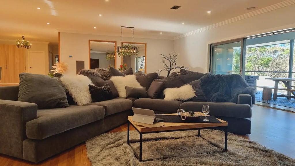 a living room with a couch and a table at Blue Mountains Sweet Retreat in Leura