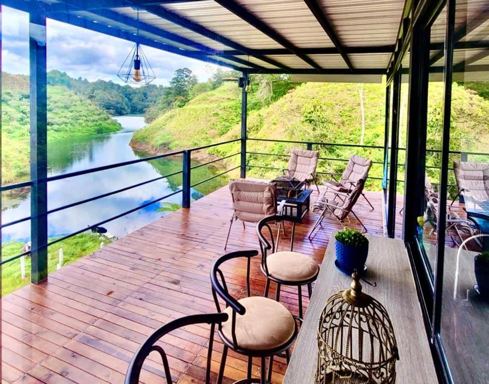 a deck with chairs and a view of a river at Cabaña Guatapé in Guatapé
