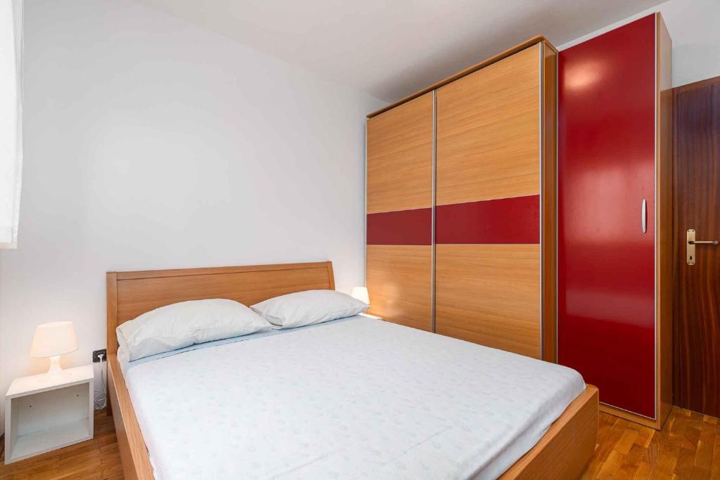 ein Schlafzimmer mit einem großen Bett und einem roten Schrank in der Unterkunft Apartment in Porec - Istrien 44235 in Poreč