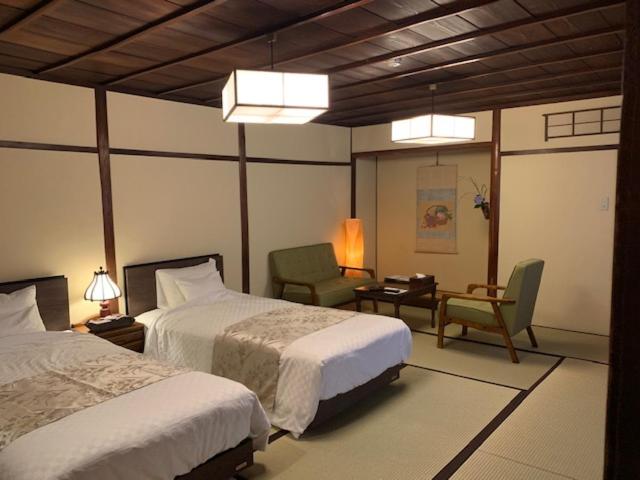 Postel nebo postele na pokoji v ubytování Yoshii Ryokan