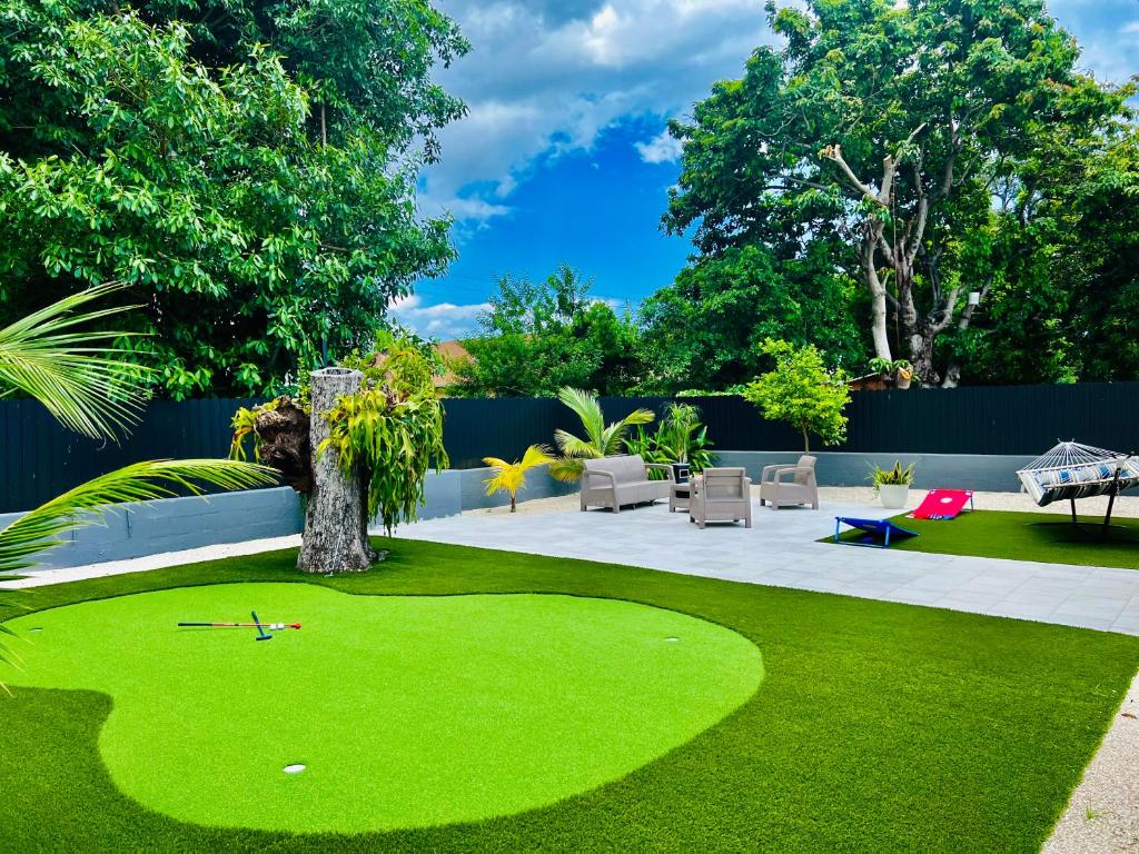 un cortile con prato verde e un putting green di Miami Lux Vacations - Villa a Miami