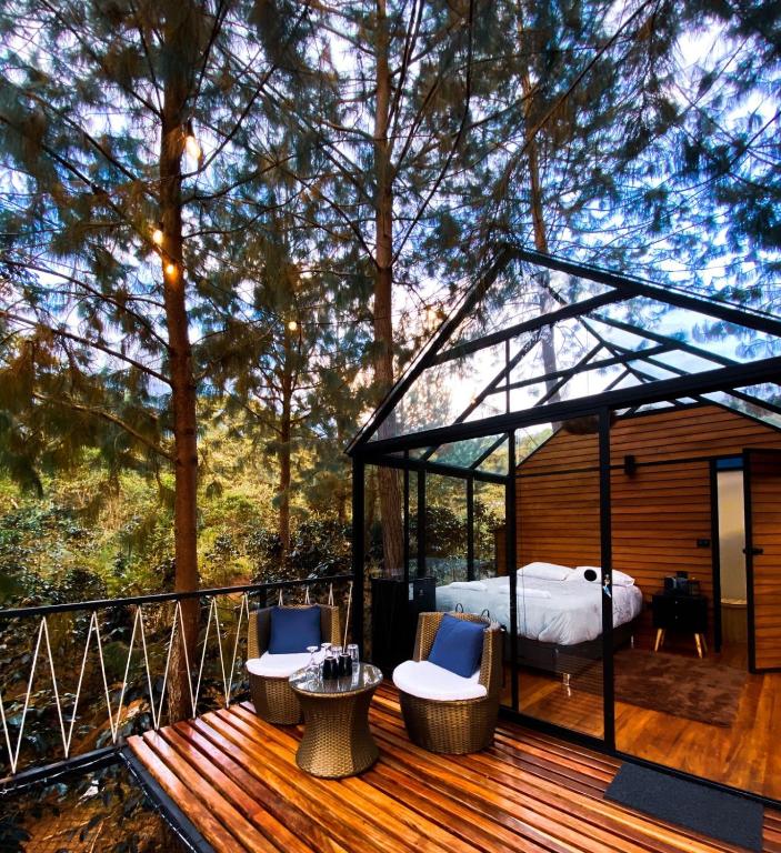 a bedroom in a gazebo on a deck at Oasis Blue Oxapampa in Palmira