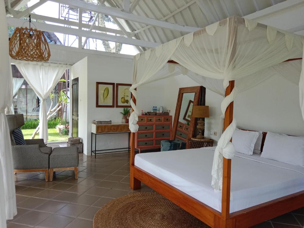 une chambre avec un lit à baldaquin dans l'établissement Le Kekeri Villas Collection, à Mataram