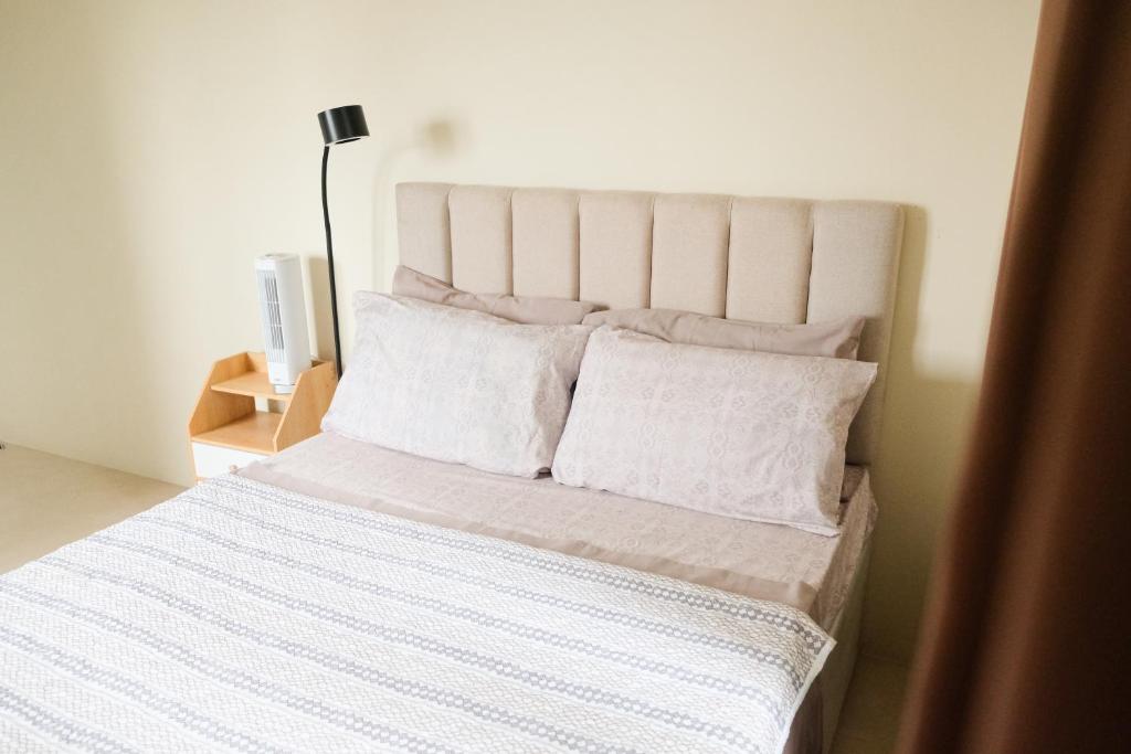 a white bed with white sheets and pillows at Spacious 1BR Corner Unit in IT Park in Cebu City