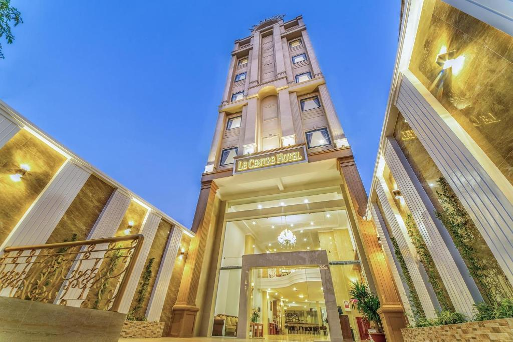 a building with a clock tower in the middle at Le Centre Pleiku Hotel in Pleiku