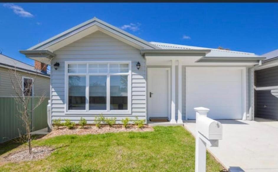 a white house with a garage at 21 On Court in Mudgee