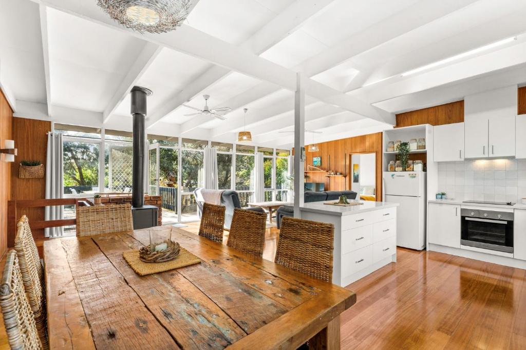 an open kitchen and dining room with a wooden table at Seabreeze at the Beach in Silverleaves in Rhyll