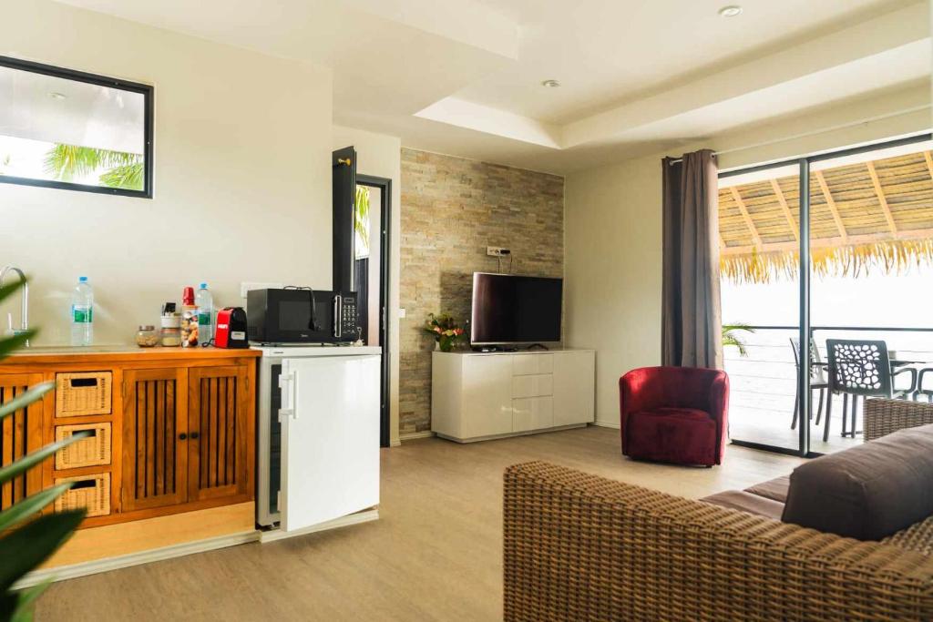 uma sala de estar com um frigorífico e uma televisão em Le Village de Vairao em Vairao