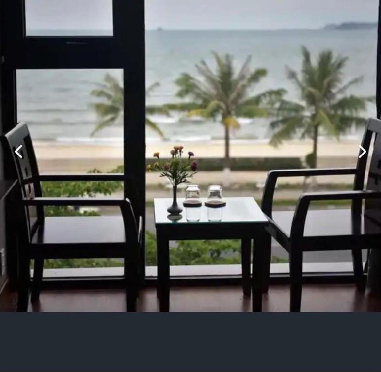 a table and chairs with a view of the beach at Holiday Inn Hotel in Da Nang