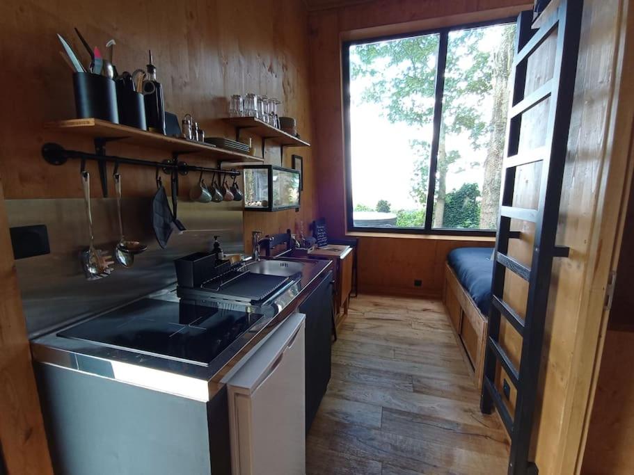 een keuken met een fornuis, een wastafel en een raam bij La Ferme 1851 - Cabane Spa Nordique privé vue sur champ 