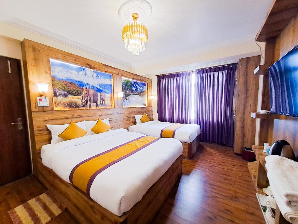 a hotel room with two beds and a chandelier at Prem Durbar Hotel & Nagarkot Zipline in Nagarkot