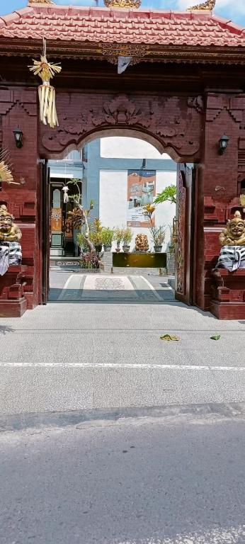an entrance to a red building with an arch at Risal Guest House in Munggu