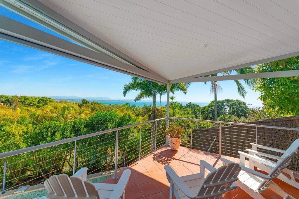 a porch with white chairs and a view of the ocean at Lee Lane Beach House - Lighthouse Rd Byron in Byron Bay