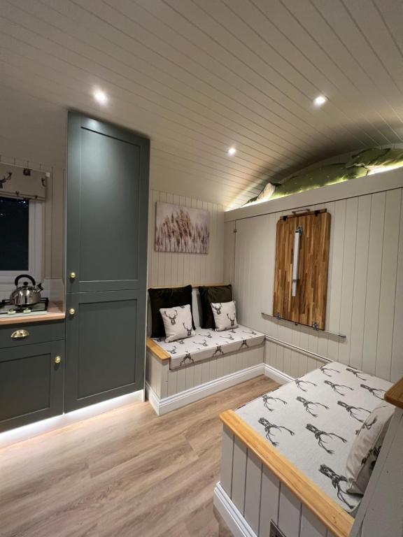 een kamer met 2 bedden en een wastafel. bij Southfield Shepards Huts in Durham