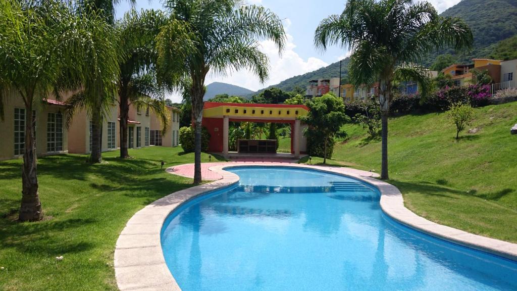 una piscina en un patio con palmeras en Casita de descanso en la Ribera de Chapala, en Chantepec