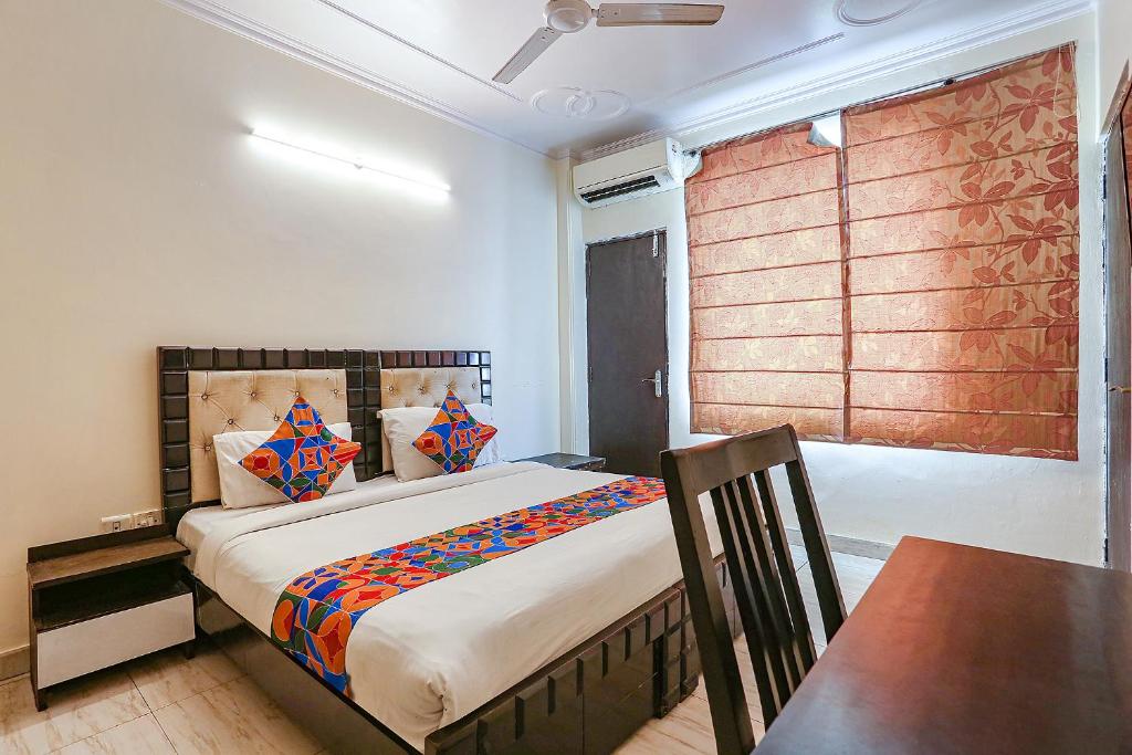 新德里的住宿－FabHotel Gera，一间卧室配有一张床、一张桌子和一个窗户。