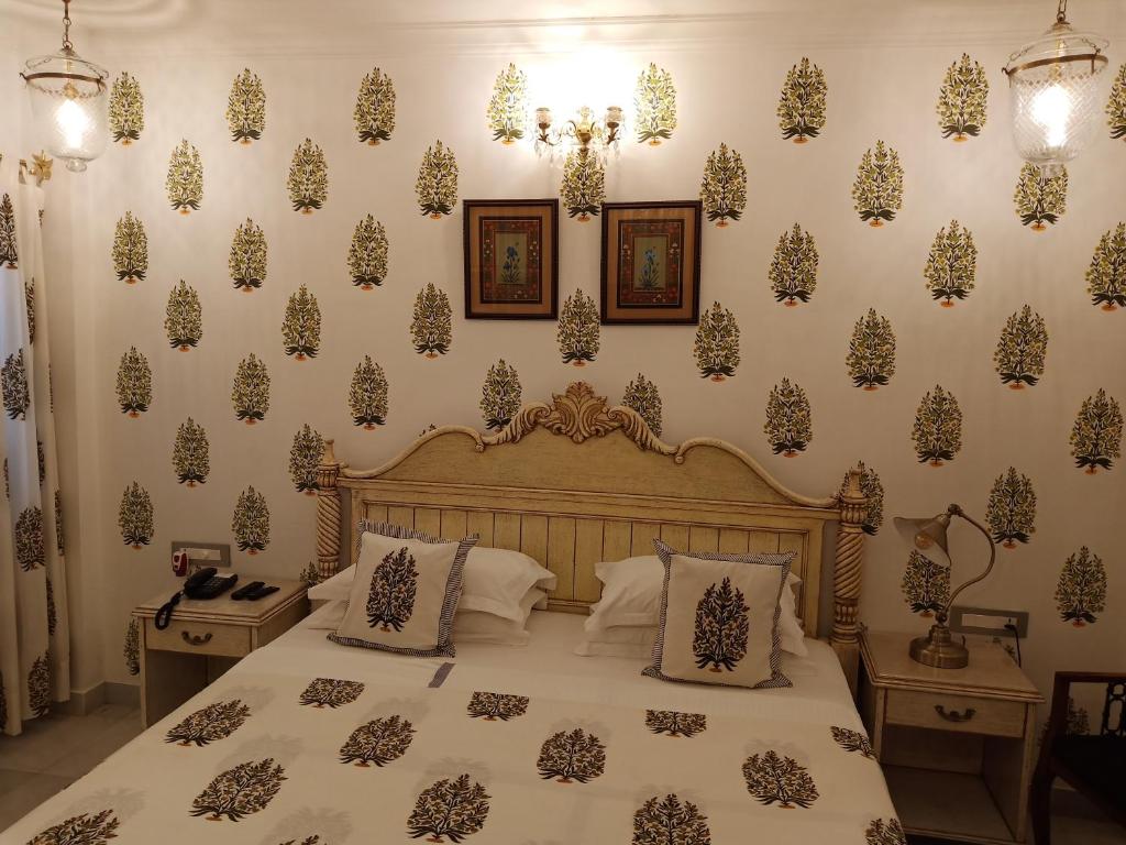 a bedroom with a bed and a wall covered in wallpaper at Jagat Niwas Palace in Udaipur