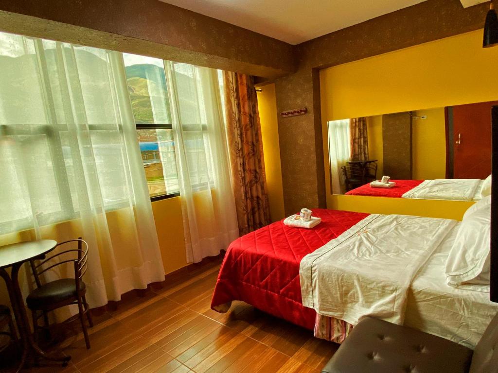 a bedroom with two beds and a mirror at HOTEL LA BELLA Y EL LEON in Huánuco