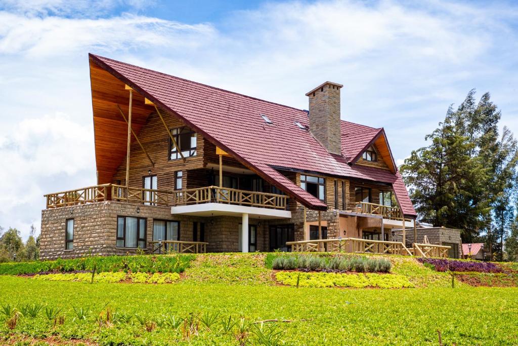 a large wooden house with a red roof at Kirimara Woodlands, Nanyuki in Nanyuki