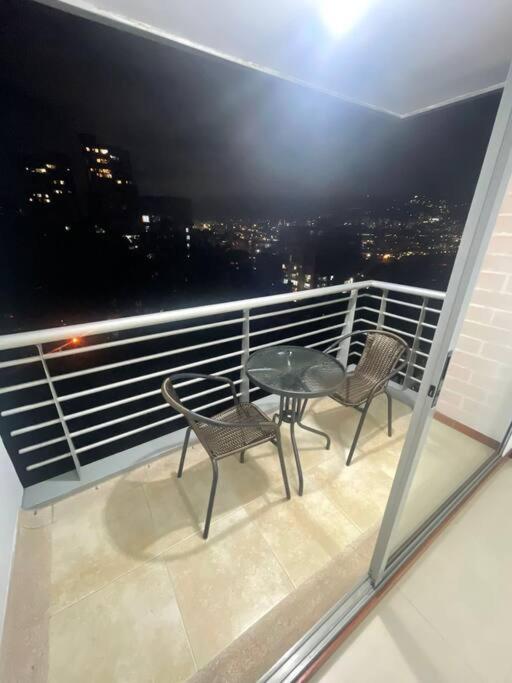 een balkon met 2 stoelen en een tafel bij Apartamento en el poblado con vista ala ciudad in Medellín