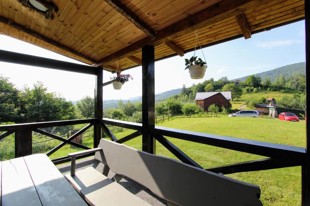 a porch with a bench and a view of a field at Котедж "Гірський Затишок" in Yaremche