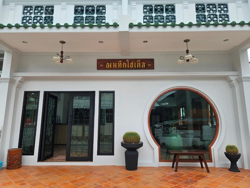 Ban Chamun (2)的住宿－ChomTique Hotel，前面有标志的建筑