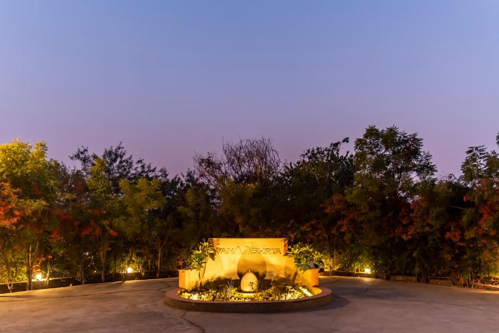a fountain in the middle of a parking lot at night at Vanaashrya Resort and Spa Sariska in Tehla
