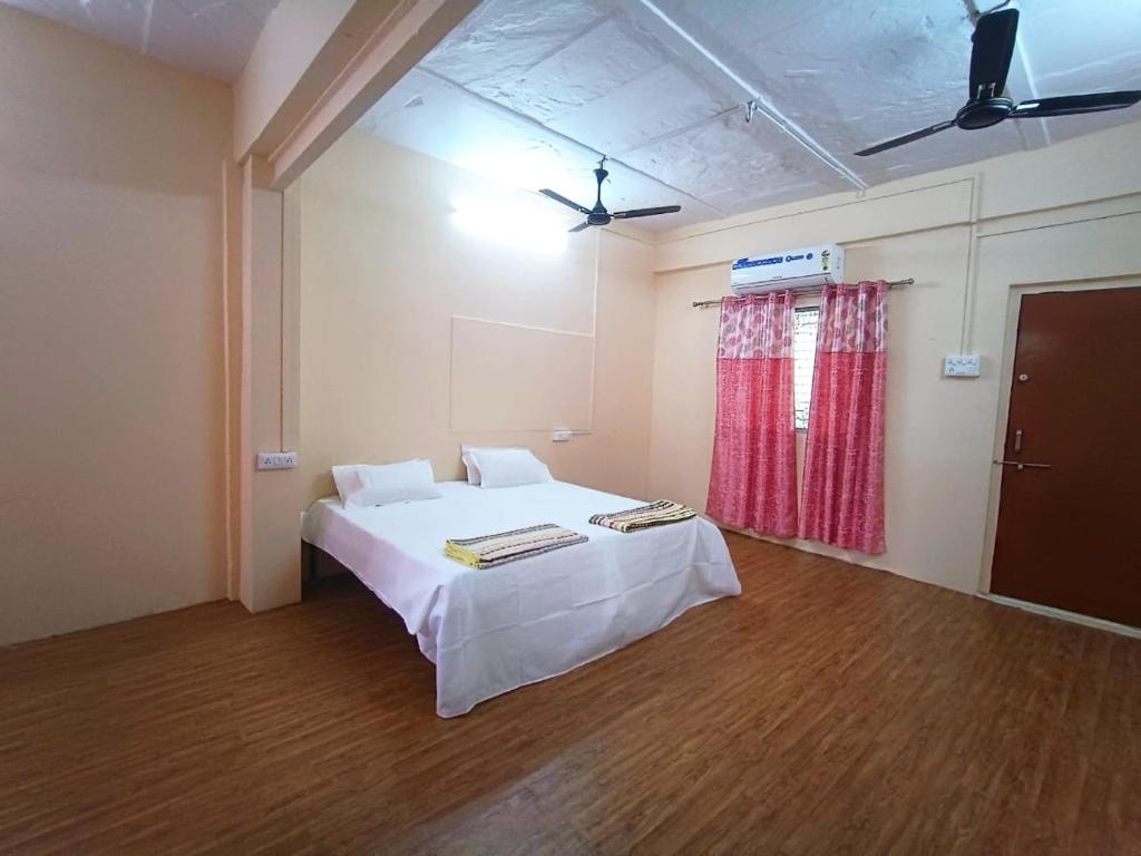 a room with a bed with a table in it at Nain Guest House in Ujjain