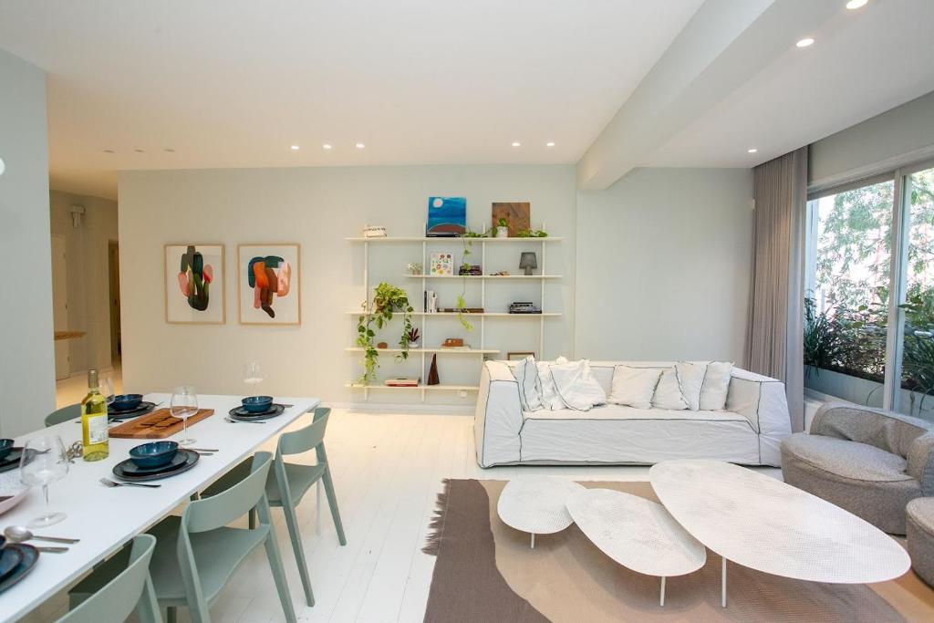 sala de estar con sofá, mesa y sillas en Huge Ultra Luxury TLV Apartment, en Tel Aviv