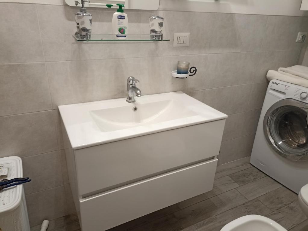 ein Badezimmer mit einem Waschbecken und einer Waschmaschine in der Unterkunft Appartamento nel cuore di Varese in Varese