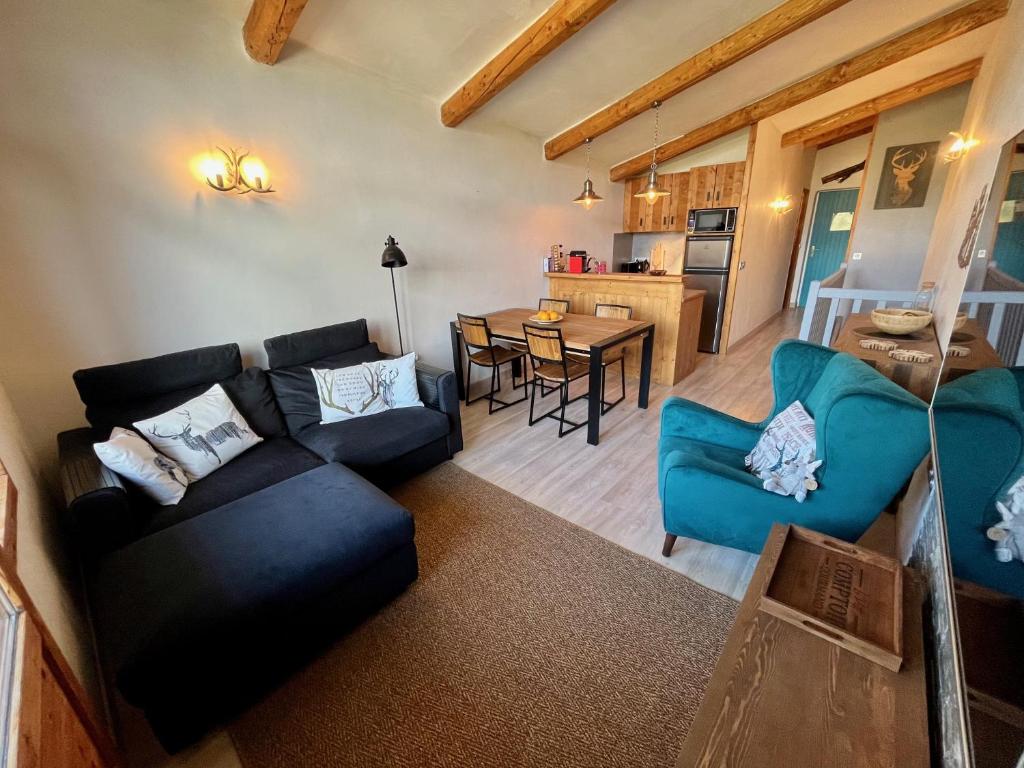 een woonkamer met een bank en een eetkamer bij Résidence Grand Bois A1124 Clés Blanches in La Tania